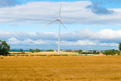 Scenic view of field against cloudy sky