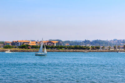 Sailboats in sea against sky