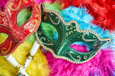 High angle view of masks on colorful feathers