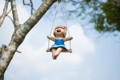 Low angle view of woman sitting on swing