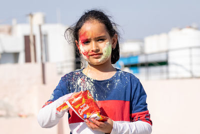 Little girl holding powdered color on the occasion of holi festival
