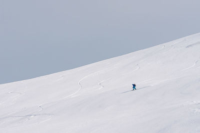 People skiing on snowcapped mountain against sky