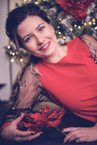 Portrait of smiling young woman holding flower