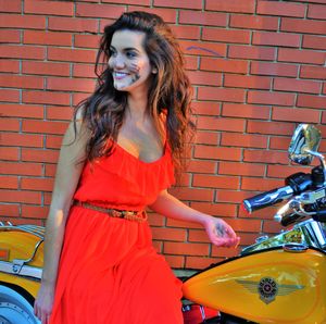 Portrait of young woman standing on a harley davidson 