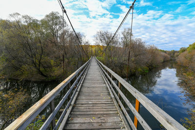 Footbridge over plants against sky