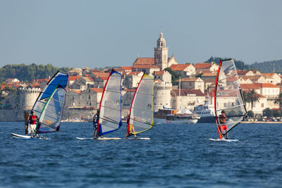 Sailboats in sea against clear sky