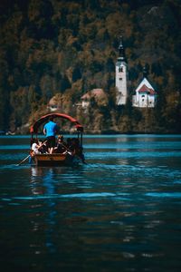 People on boat sailing in lake bled