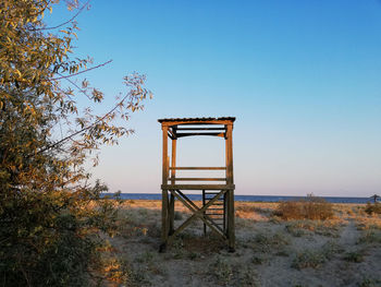 Lifeguard hut on field against clear sky