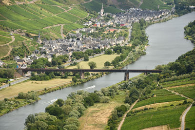 Bird's eye view of a village near the moselle loop surrounded by greenery and vineyards in germany