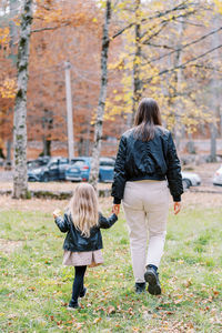 Rear view of woman walking on field