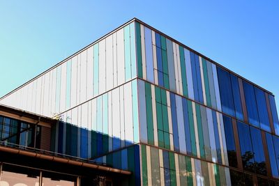 Low angle view of modern building against clear blue sky