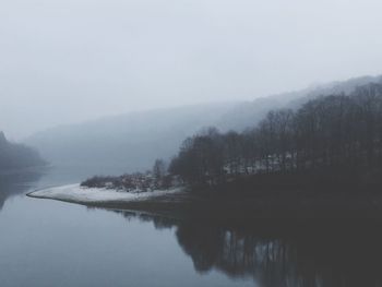 Scenic view of lake against sky during foggy weather