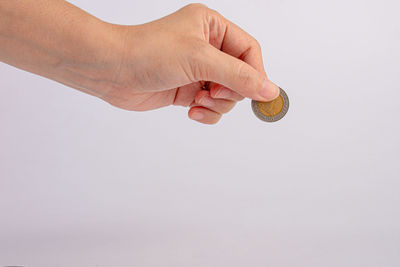 Midsection of person holding hands against white background