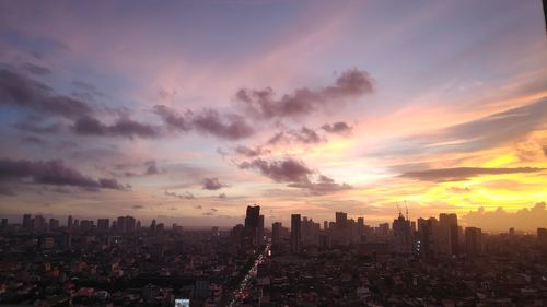 Aerial view of buildings in city during sunset