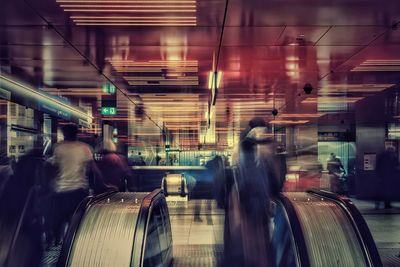 Blurred motion of man walking in illuminated underground walkway
