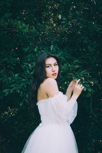 Portrait of woman standing against plants