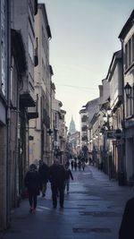 People walking on street amidst buildings in city