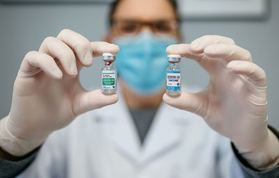 Midsection of doctor holding dentures
