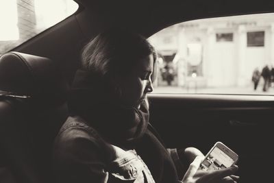 Side view of a young man sitting in car