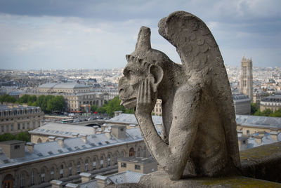 Gargoyle thinking on top of notre dame de paris