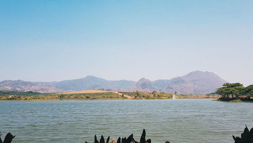 Scenic view of lake against clear blue sky