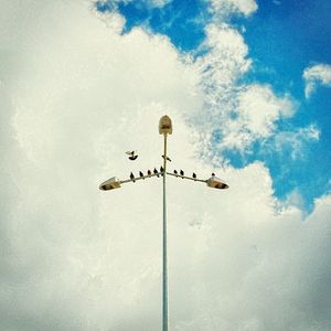 Low angle view of street light against cloudy sky
