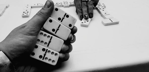 Cropped hands of friends playing dominoes at table