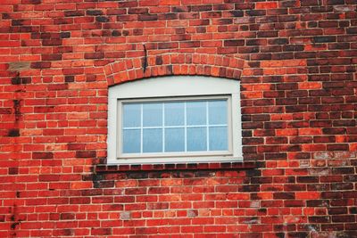 Low angle view of window on brick wall