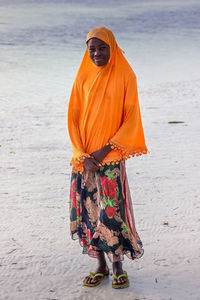 Full length portrait of girl standing at beach