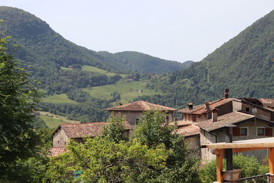 Scenic view of village by mountains against sky