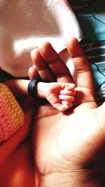 Close-up of father holding baby hand