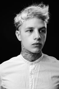 Portrait of young man against black background