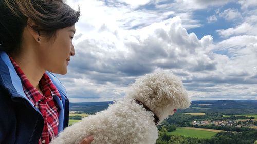 Woman with dog against sky