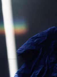 Close-up of wet person against blue wall