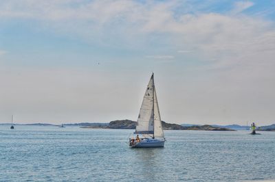 Sailboat sailing on sea against sky