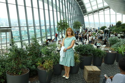 Portrait of woman standing in greenhouse