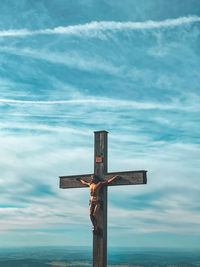 Low angle view of wooden cross against sky