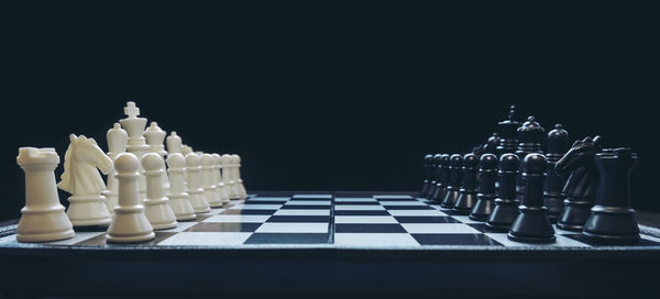 Chess pieces on board against black background