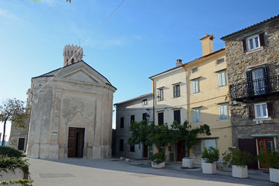 Low angle view of street amidst buildings against sky