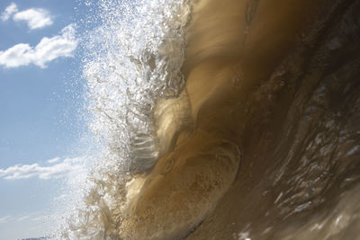 Close-up of sea waves splashing against sky