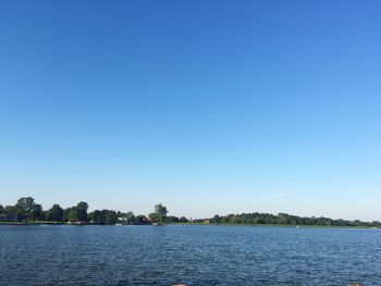 Scenic view of lake against clear blue sky