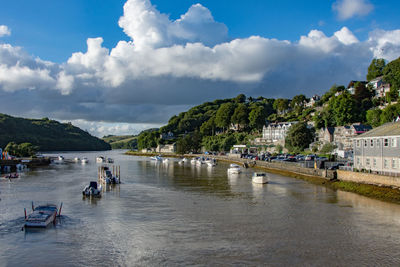 People on river against cloudy sky