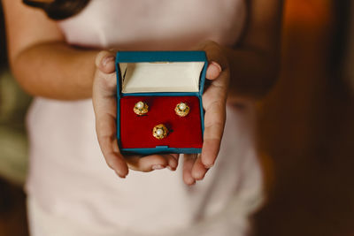 Midsection of woman holding rings in box