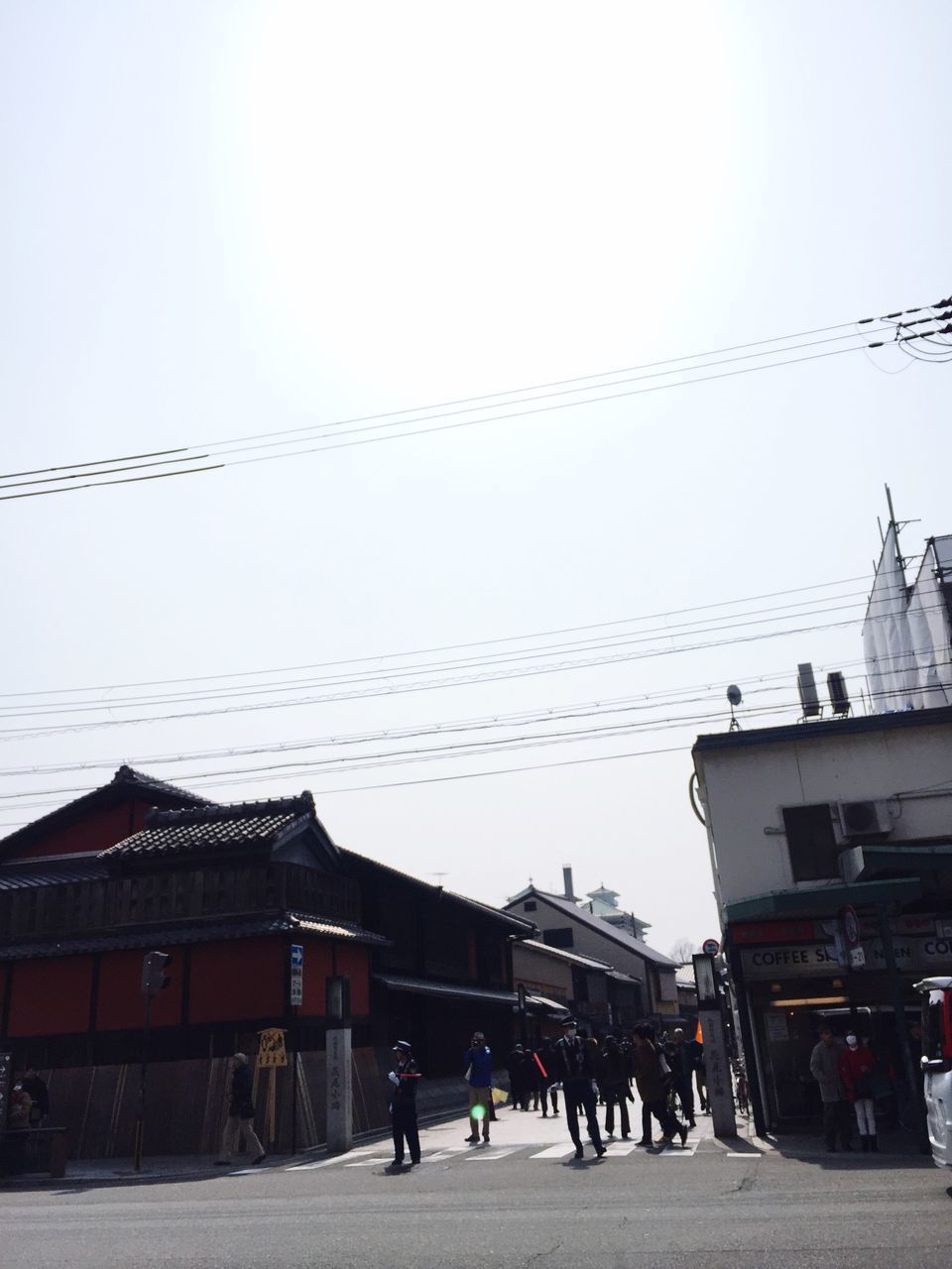 architecture, building exterior, built structure, clear sky, street, walking, person, men, house, sky, cable, street light, road, outdoors, residential structure, the way forward, city, residential building, power line