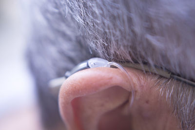 Close-up of man ear with hearing aid