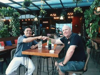 Friends sitting on table at restaurant