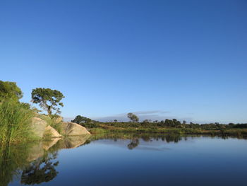 Calm sea against clear blue sky