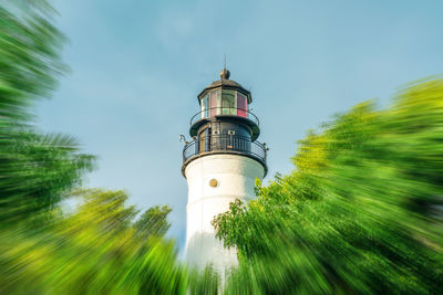 Lighthouse by sea against sky