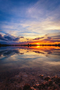 Scenic view of sea against dramatic sky during sunset