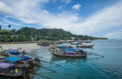 Boats moored in sea against sky